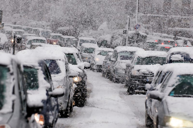 Cars stuck in traffic as heavy snowfall comes down. 