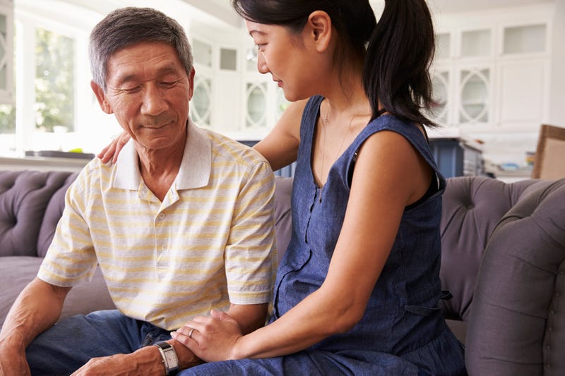 Adult Daughter Talking To Depressed Father At Home