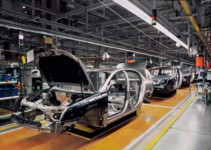 A car chassis moves through the production line in a factory.