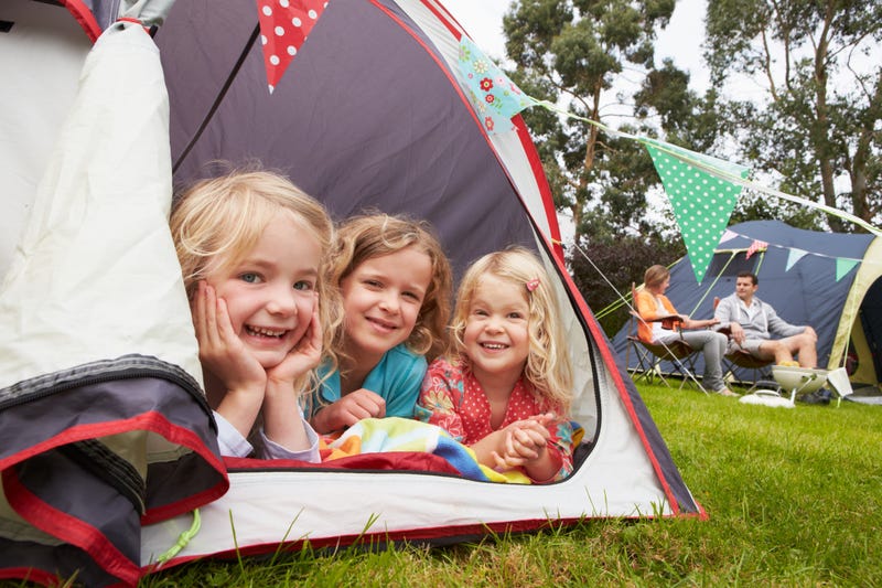 children of family in tent at tailgate