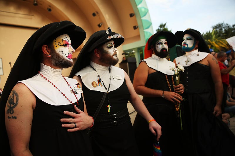 four people in sleeveless nun outfits with colorful costume makeup