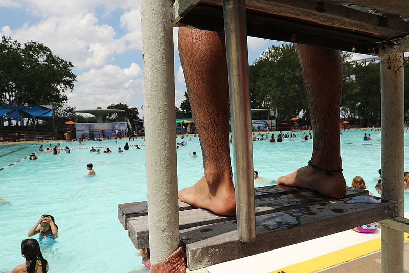 A lifeguard watches as people enjoy a hot afternoon