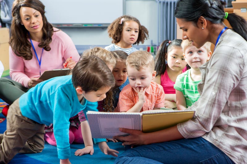 Stock photo of teacher reading to kindergartners