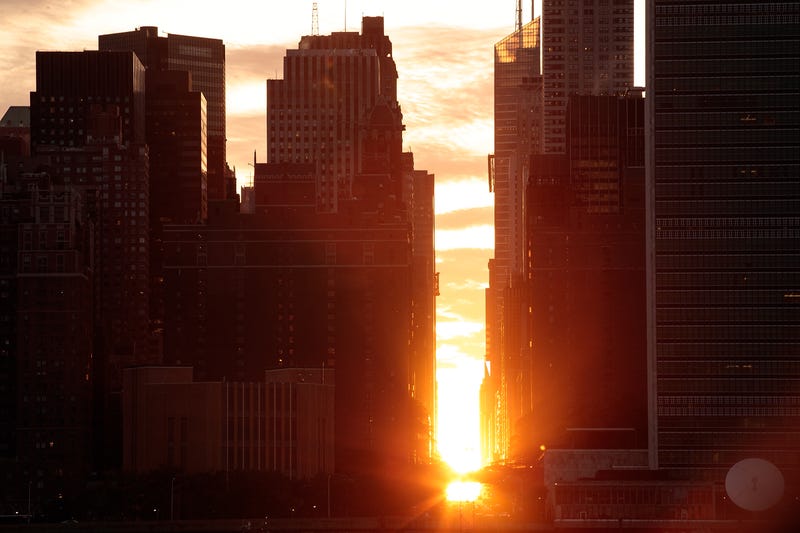 A view of the 'Manhattanhenge' sunset from Hunters Point South Park, July 11, 2016 in the Queens borough of New York City. 'Manhattanhenge' is created when the setting sun aligns with the city's street grid.