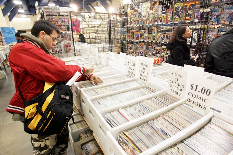A comic book collector browses comics at a convention.