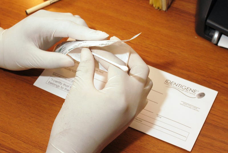Ronald Ford Jr. places a cotton swab that was used for DNA testing back into a wrapper, as the swab is prepared to be sent in the envelope to a lab, at City Coffee February 8, 2006 in Camden, New Jersey.
