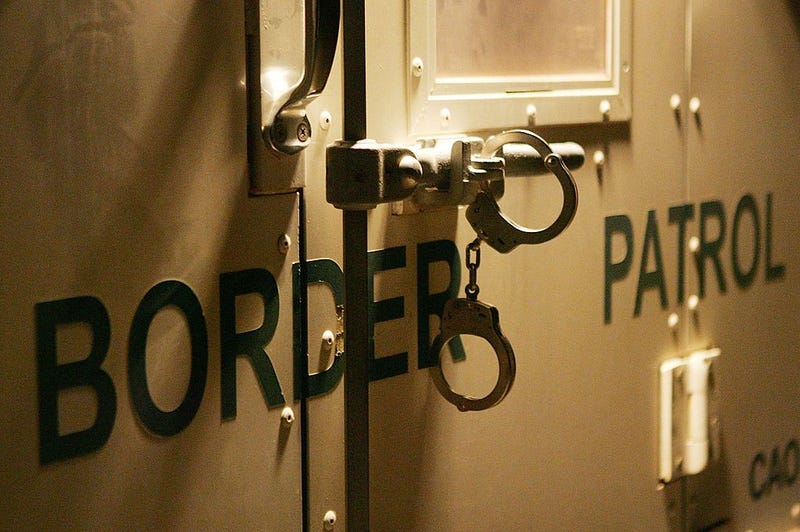 Handcuffs secure the back door of a US Customs and Border Protection border patrol vehicle loaded with suspected illegal immigrants on the California side of the Colorado River on March 17, 2006 near Yuma, Arizona.
