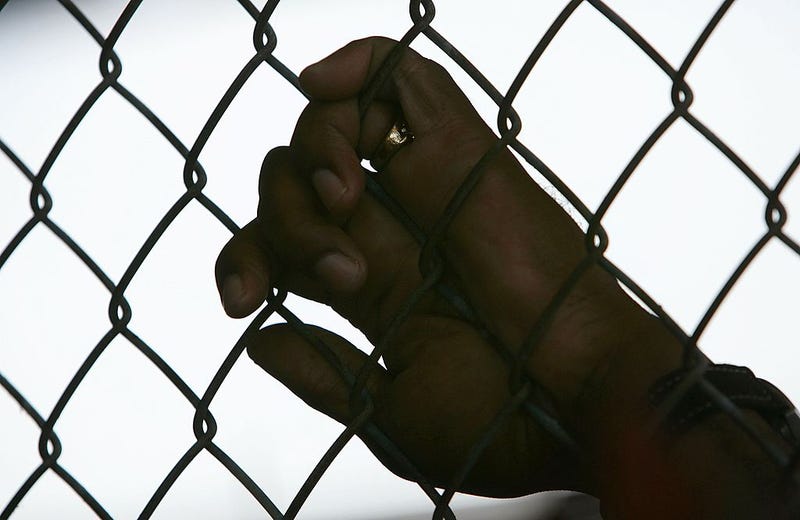  An inmate holds onto a fence during the Angola Prison Rodeo at the Louisiana State Penitentiary April 23, 2006 in Angola, Louisiana. 