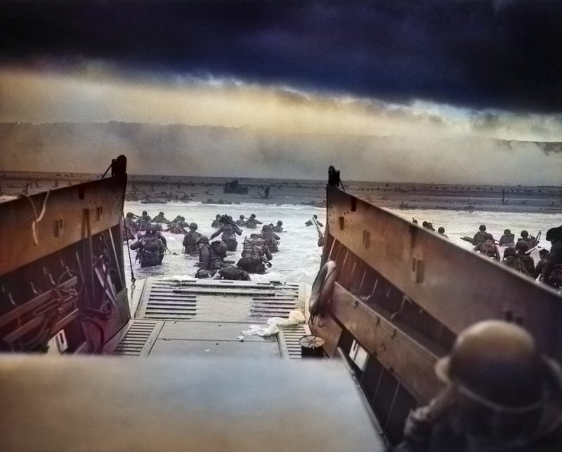 Digitally colorized image of "Into the Jaws of Death," a photograph by Robert F. Sargent, of the U.S. Army First Infantry Division, disembarking from an LCVP (landing craft) onto Omaha Beach during the D-Day on June 6, 1944