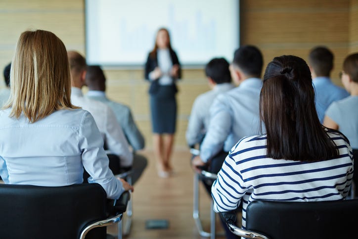 Rear view of people sitting at business seminar