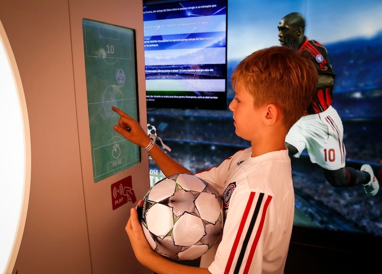 Fan plays games in the UEFA Champions League Trophy Tour Truck at Atheneum Square during the UEFA Champions League Trophy Tours