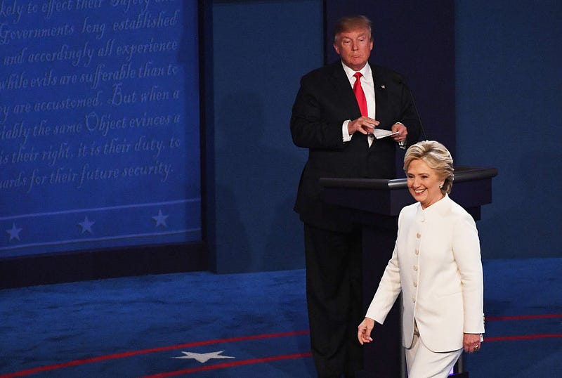 Democratic presidential nominee former Secretary of State Hillary Clinton walks off stage as Republican presidential nominee Donald Trump looks on during the third U.S. presidential debate at the Thomas & Mack Center on October 19, 2016 in Las Vegas, Nevada.