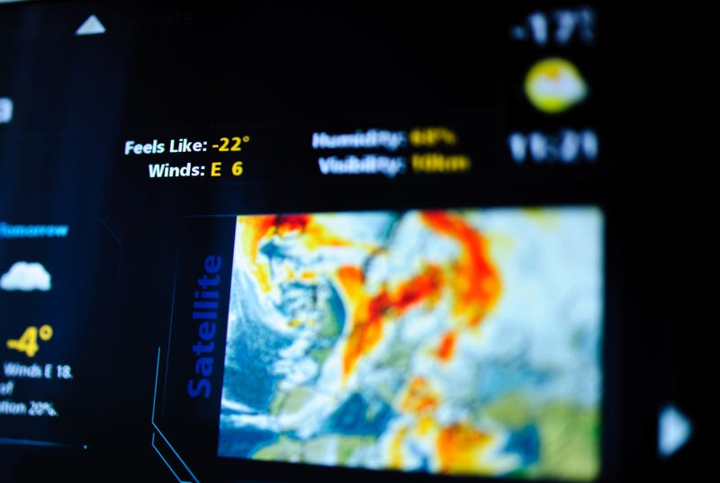 Digital weather forecast interface on a modern digital display showing cold weather for the next day eaturing an unrecognizable weather map. Tilt-shift lens used to outline the feels like -22 symbol