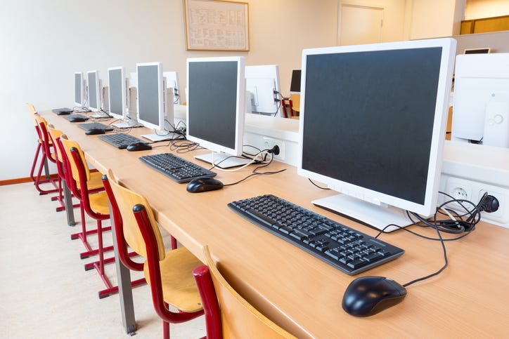 Computer lab with several desktops, keyboards and computer mouses.