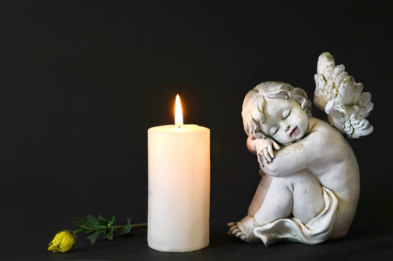 White candle, an angel and flower