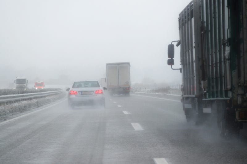 driving in dangerous winter weather with poor visibility during snow and rain on the highway