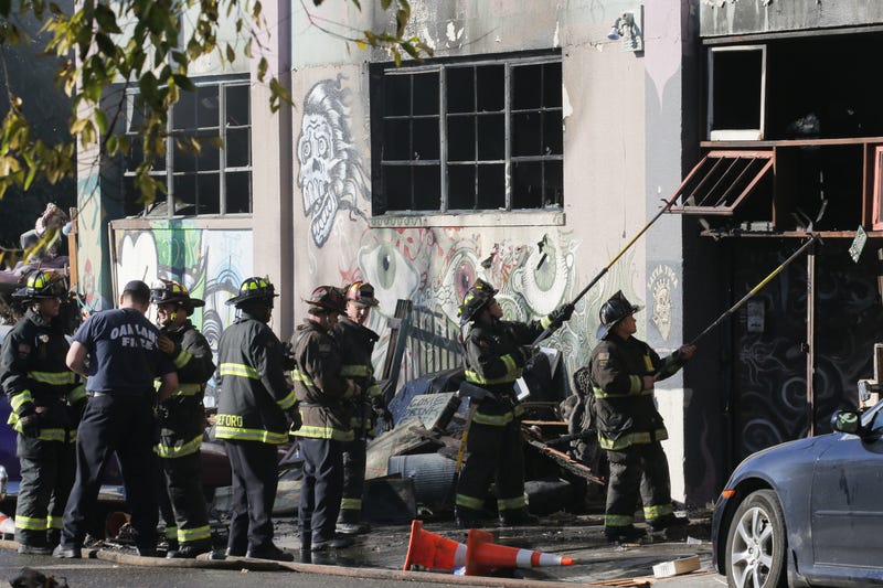 Firefighters work to clear the debris from a doorway following a fire that claimed the lives of 36 people at a warehouse in the Fruitvale neighborhood on December 3, 2016 in Oakland, California.