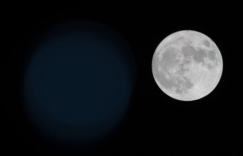 The cold moon or beaver moon rises behind One Vanderbilt and the Empire State Building in New York City and homes in Jersey City, New Jersey on November 29, 2020 as seen from Newark, New Jersey.