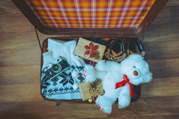 open suitcase with holiday gifts inside