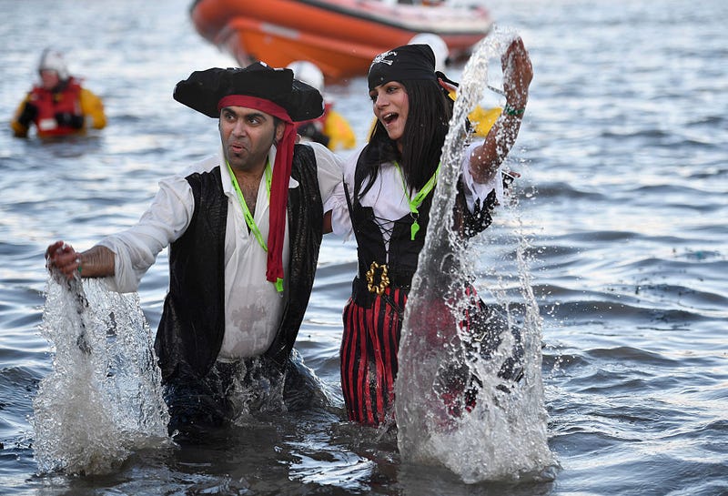 A couple dressed as pirates splash around in the water as they join around 1,000 New Year swimmers, many in costume, in front of the Forth Rail Bridge during the annual Loony Dook Swim in the River Forth on January 1, 2017 in South Queensferry, Scotland. 