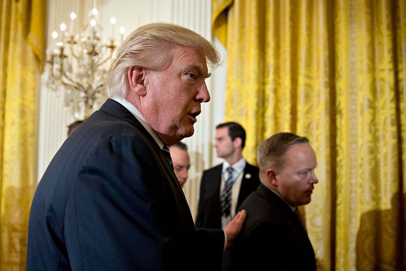 U.S. President Donald Trump walks out with Sean Spicer, White House press secretary (R) during a swearing in ceremony of White House senior staff in the East Room of the White House on January 22, 2017 in Washington, DC.