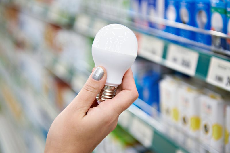 Woman holding a light bulb at the store. 