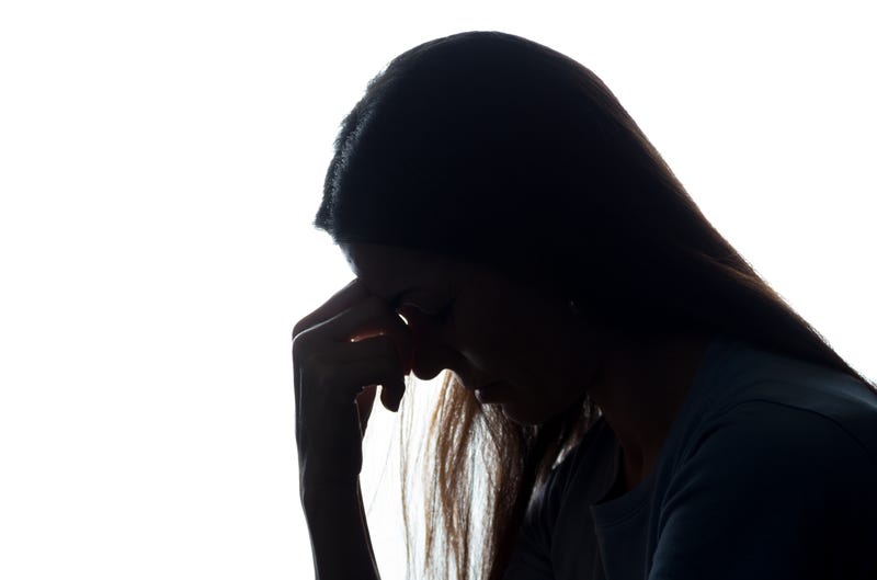 Silhouette of a young woman with her head down