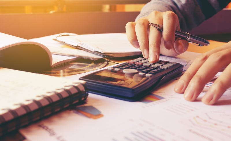 Woman using calculator with doing finance at home office