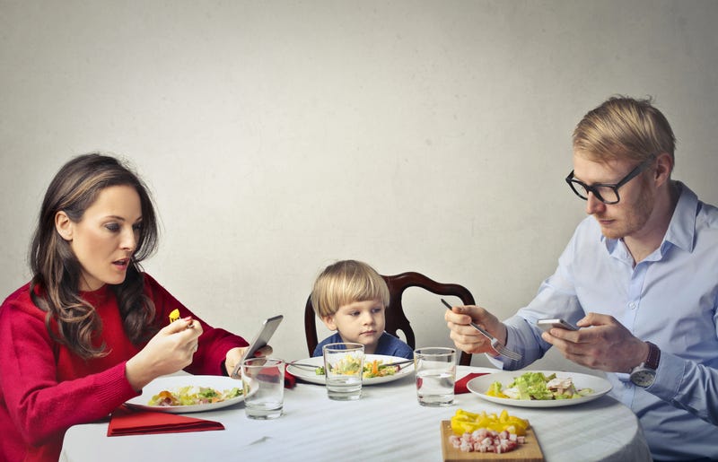Parents are using their phones during dinner