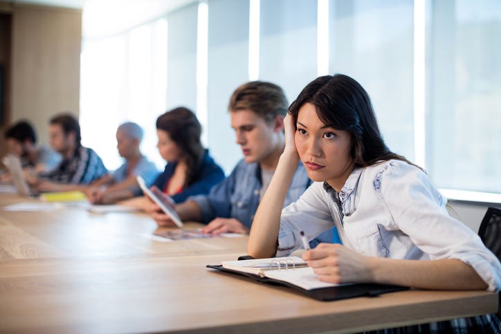 woman sits in a boring meeting