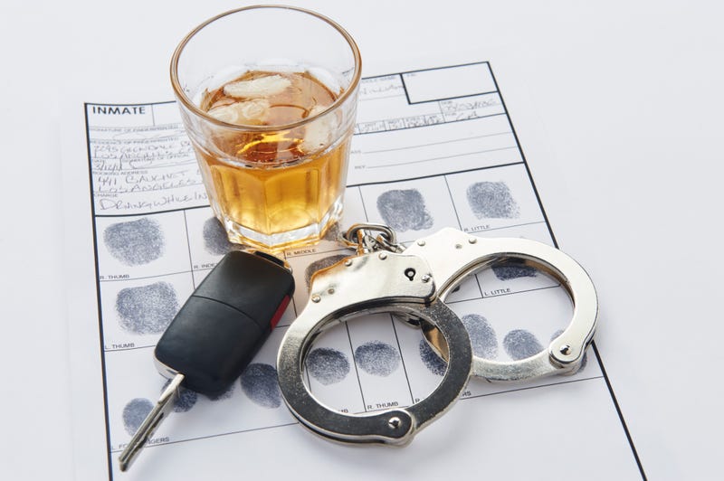 A glass of alcohol, a car key, handcuffs, and a fingerprints sheet