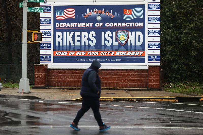 A person walks near the entrance to Rikers Island in Queens