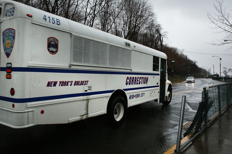 A corrections bus enters Rikers Island