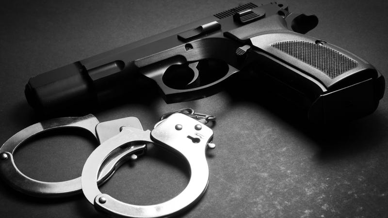 Handgun with handcuffs - stock photo