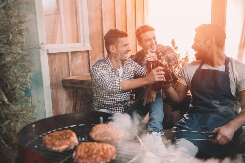 men having a beer by the grill