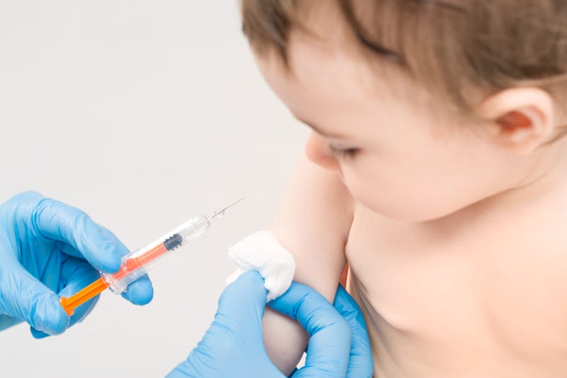 Baby getting a vaccine shot. 