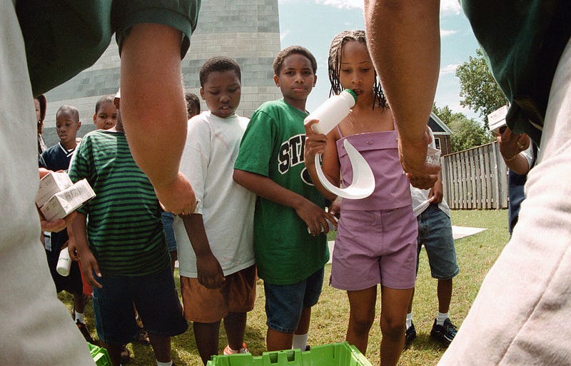 Workers from Peapod online grocery service hand out free refreshments to day campers at the James Jordan Boys & Girls Club and Family Life Center July 12, 2000 in Chicago. A caravan of more than 20 Peapod trucks traveled from their distribution center in Niles, IL. to the club and center named for James Jordan, father of Chicago Bulls basketball great Michael Jordan, to deliver the first of multiple $1,000 grocery donations. Peapod is Chicago's leading online grocery service and is celebrating its 10th anniversary and new free delivery in the city. 