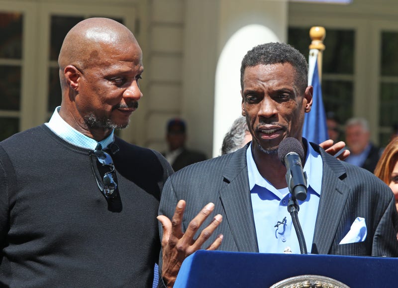 Darryl Strawberry puts a comradely arm around Dwight Gooden while standing on podium on April 28, 2017 in New York City. Gooden, who has long struggled with alcohol & cocaine addiction, had been incapacitated & unable to participate in the team's victory parade along Broadway thirty-one years prior.