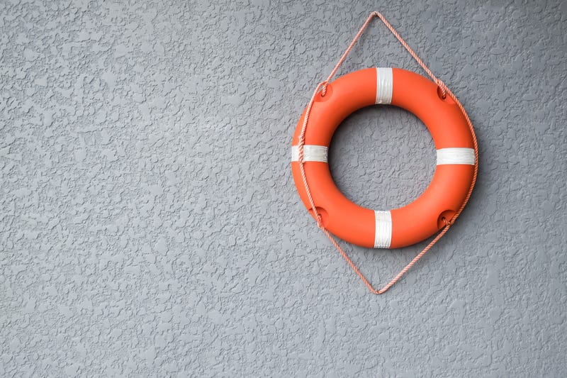 Orange life buoy hang on the grey wall