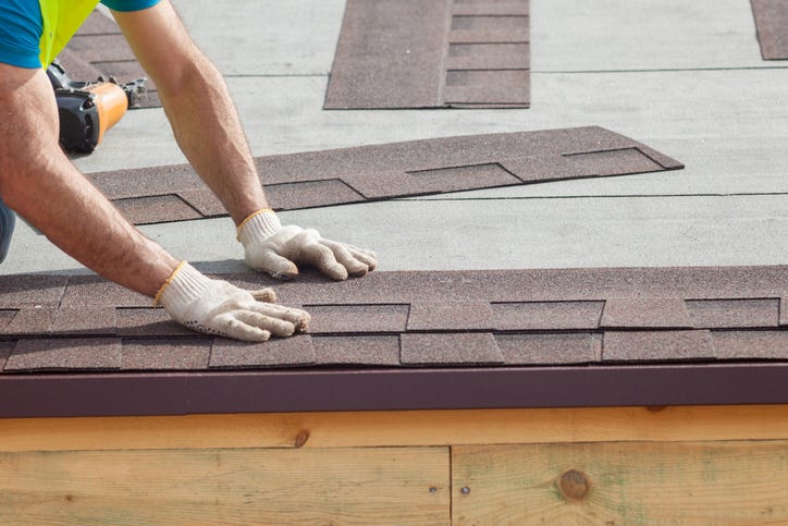 Roofer installing shingles.