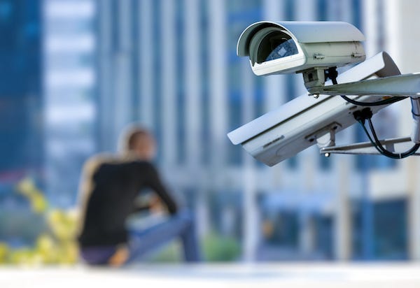 Security cameras with blurry man sitting in the background