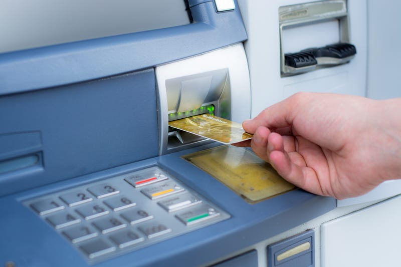 man inserts card into ATM