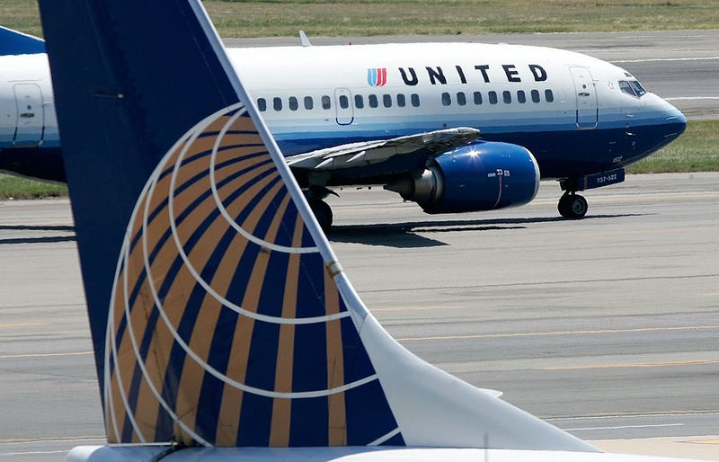 A United Airlines aircraft passes by a Continental Airlines aircraft as it taxis to takeoff from the runway of Ronald Reagan National Airport August 16, 2006 in Washington, DC.