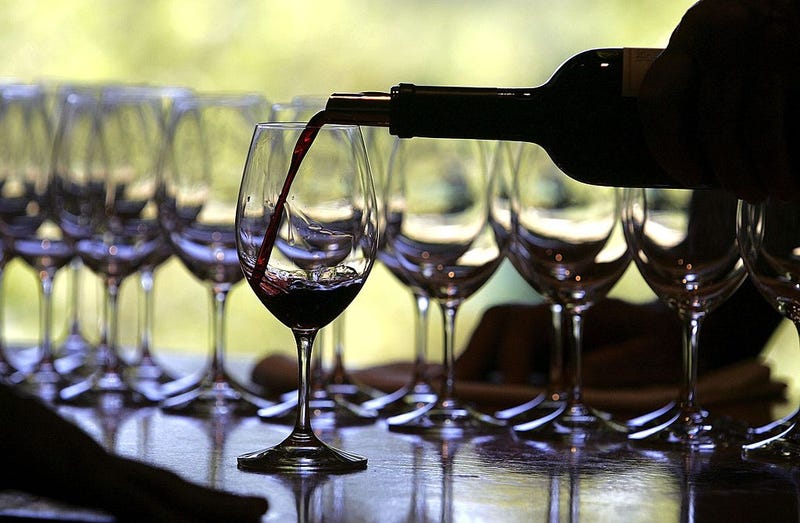 A worker at St. Supery winery pours a glass of wine for a tasting September 20, 2006 in Rutherford, California.