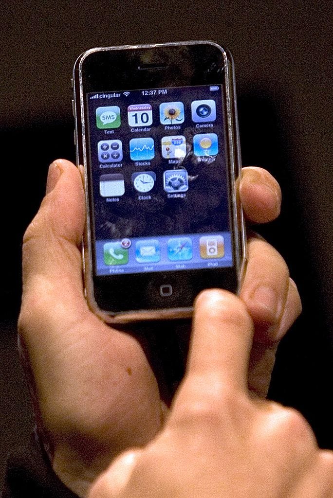 An Apple employee gives a demonstration of the new iPhone at MacWorld on January 10, 2007 in San Francisco, California. The device which is controlled by a touch screen is set to launch in June 2007. It will play music, surf the Internet and deliver voice mail and e-mail. According to reports, Cisco Systems Inc. is suing Apple Inc. for using Cisco's registered iPhone trademark for the device. (Photo by David Paul Morris/Getty Images)
