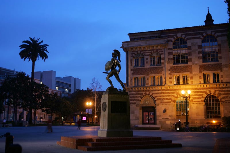trojan statue in a dark courtyard on campus