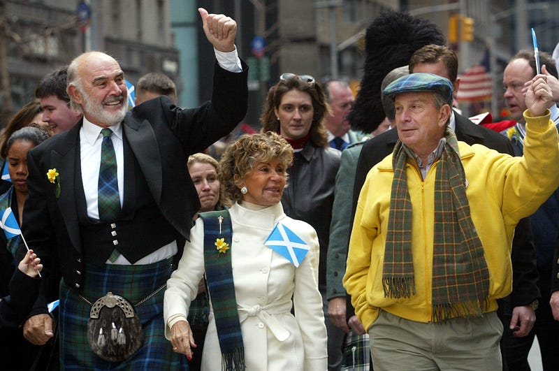 Sean Connery (L), his wife Micheline Roquebrune and New York City Mayor Michael Bloomberg wave to the crowd as they march up Sixth Avenue during the world's largest pipe and drum parade to celebrate Scottish Tartan Day April 6, 2002 in New York City. Approximately 10,000 participants marched in the parade which was led by Connery.