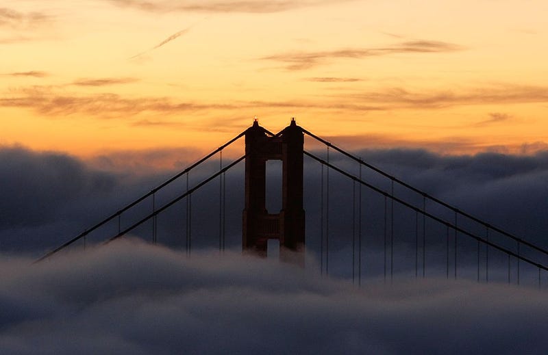 The north tower of the Golden Gate Bridge is blanketed by fog as the sun rises October 8, 2007 in Sausalito, California.