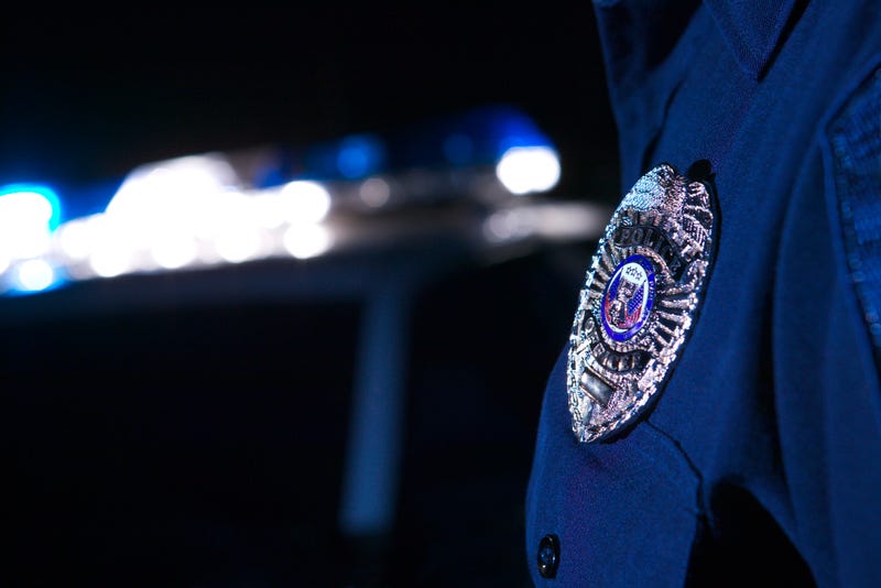 policeman's badge with police lights in background