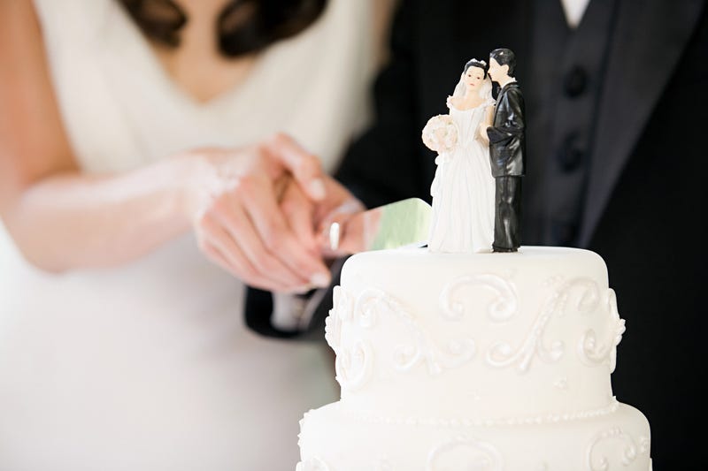 Newlyweds cutting wedding cake - stock photo